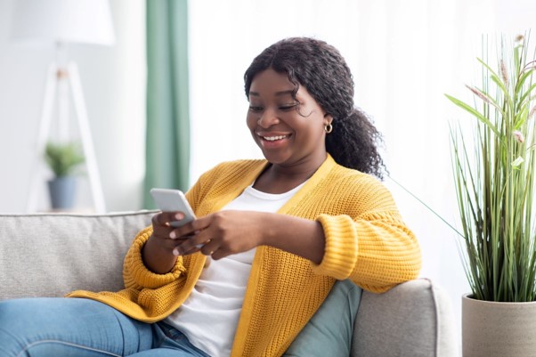 jeune femme regardant son téléphone en souriant