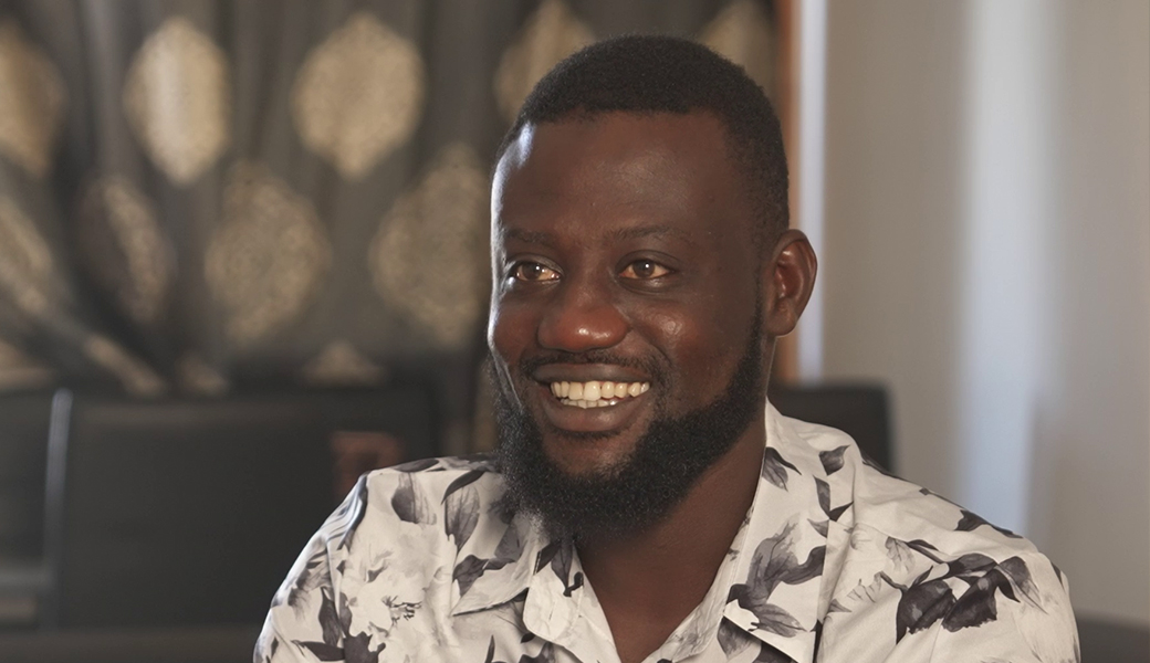 Un homme souriant face caméra