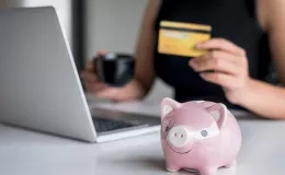 une femme tiens en mains une carte de crédit